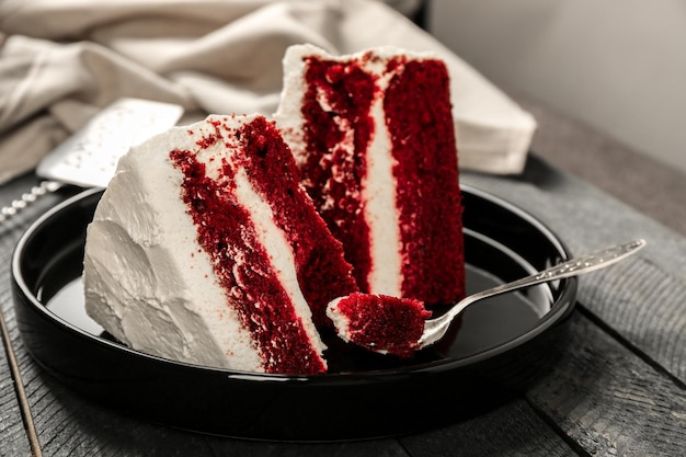 Slices of delicious red velvet cake on black plate