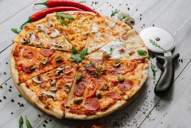 A slices on different kinds of pizza set in one rounded piece on wooden background