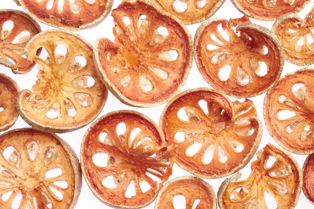 Slices of dried bael fruit on white background