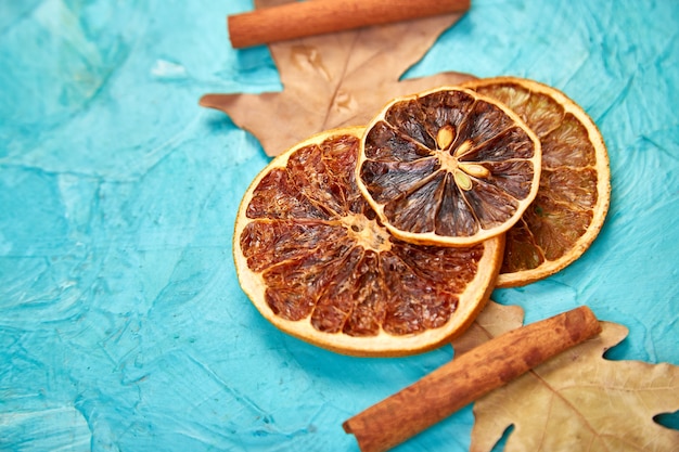 slices of dried oranges, leaves and cinnamon, autumn concept, flat lay, top view