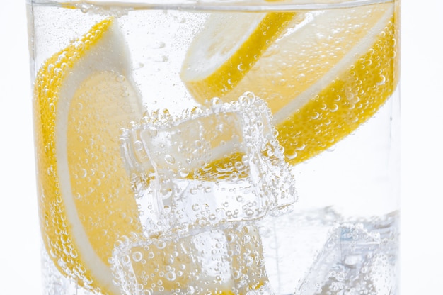 Fette di limone fresco succoso nel cocktail con acqua cristallina.