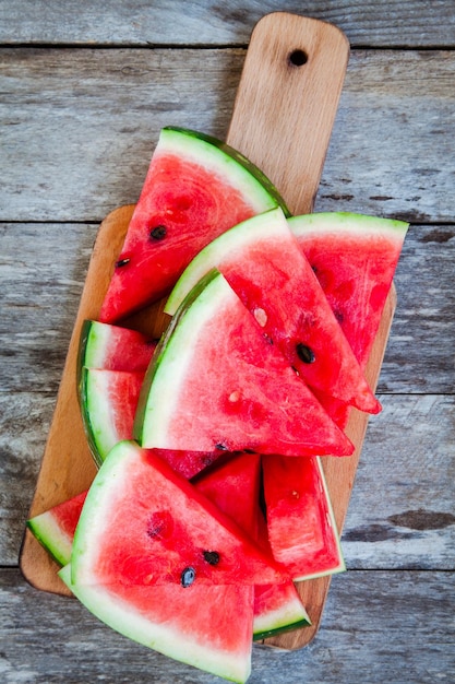 Slices of fresh juicy organic watermelon on a wooden background