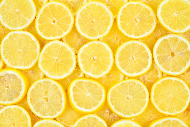 A slices of fresh juicy yellow lemons.  Texture background, pattern.