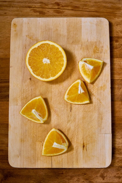 Slices of fresh organic orange on a wooden cutting board.