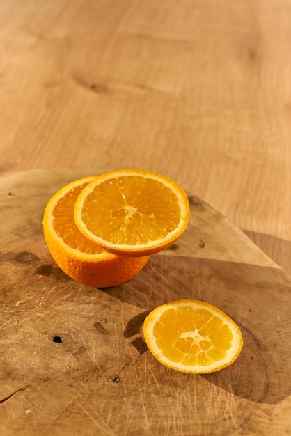 Slices of fresh organic oranges on a wooden kitchen table.