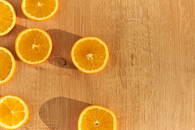 Slices of fresh organic oranges on a wooden kitchen table.