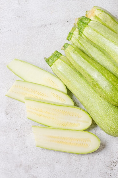 Slices of fresh vegetable marrow on light background