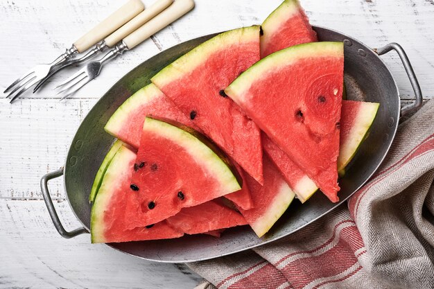 Photo slices of fresh watermelon in plate on wooden background. mock up for design. copy space.