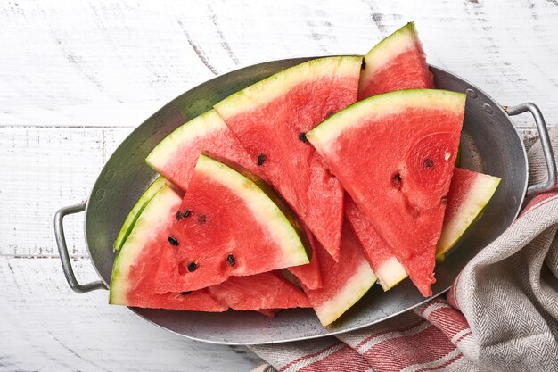 Slices of fresh watermelon in plate on wooden background. Mock up for design. Copy space.