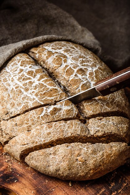 Slices of homemade rye bread on cutting board with knife