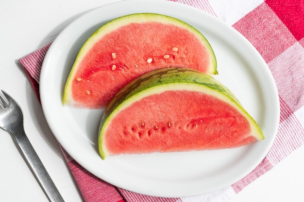 Slices of juicy watermelon on a plate on a white table summer berry