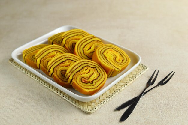 Slices of Lapis Legit Gulung or Roll Thousand Layers Cake in white plate