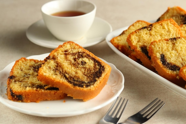 Slices of Marble Bundt Cake on White Plate, served with a cup of tea