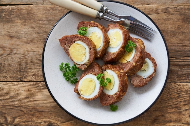 Slices of meatloaf with boiled eggs on a plate