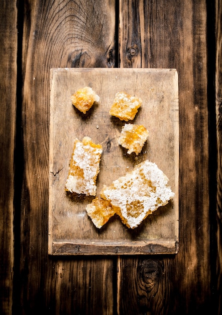 Slices of natural honey in the comb on the Board. On wooden background.