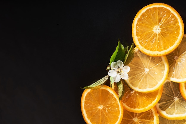 Slices of orange and lemon, isolated on a black.