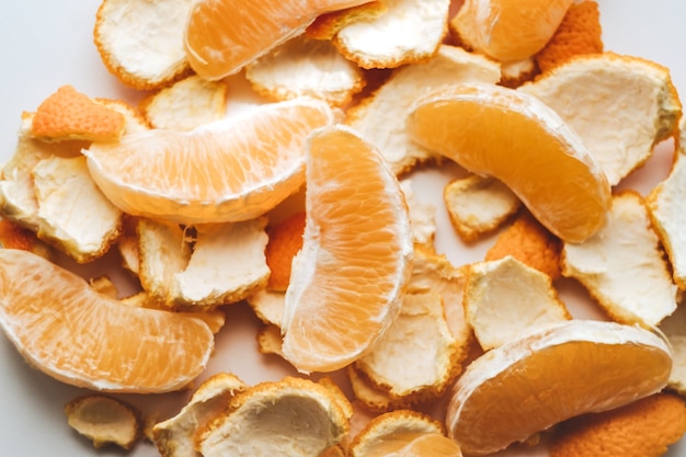 Slices of orange and peel on a white