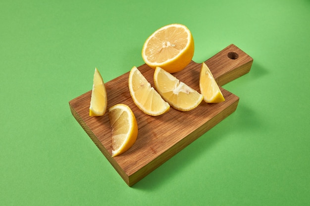 Slices of organic fresh yellow lemon on a wooden cutting board