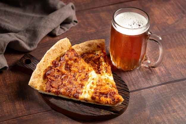 Slices of pizza with glass of beer on the table