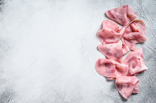 Slices of Pork ham. Fresh prosciutto.  White background. Top view. Copy space.