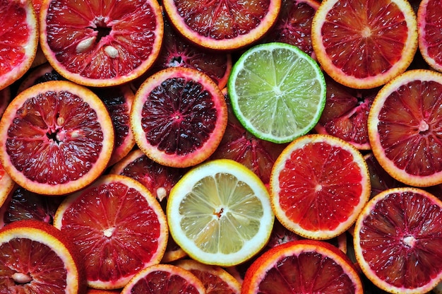 slices of red sicilian oranges lemon and lime background