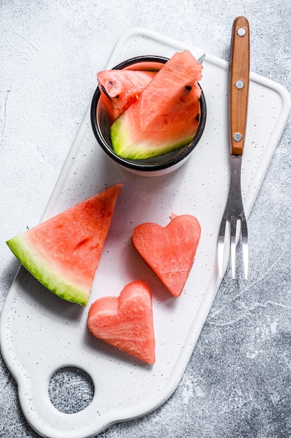 Slices of ripe watermelon in the shape of a heart. Concept of love. Gray background