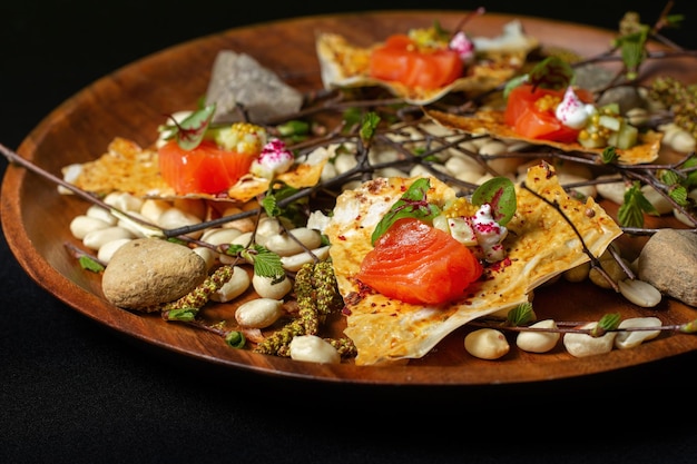 Slices of salmon on scraps of cakes with spices with peanuts stones and sprigs Clouseup