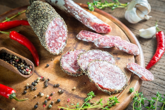 Slices of saucisson and fuet on the wooden board