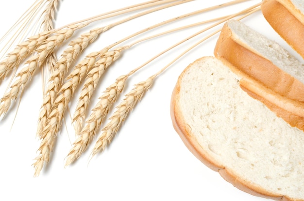 Slices of sliced bread and wheat on a white background closeup