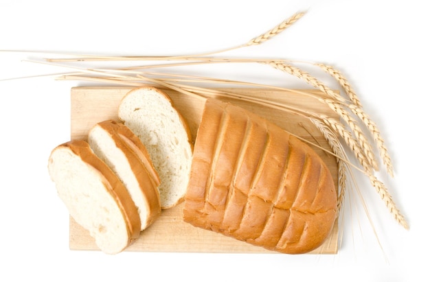 白い背景のクローズアップでスライスされたパンと小麦のスライス