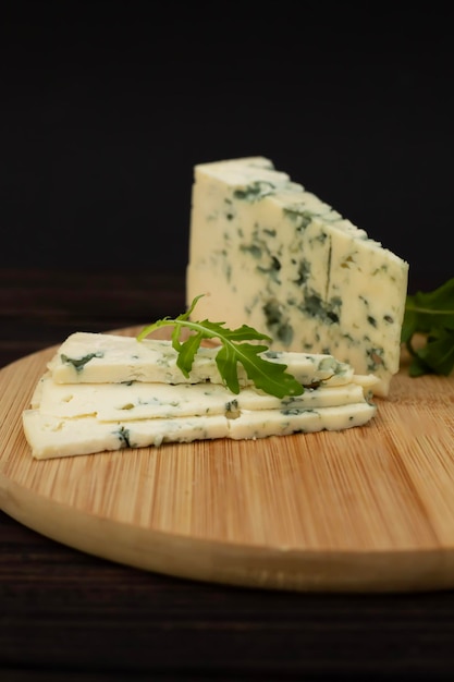 Slices of sliced cheese with mold on a wooden tray