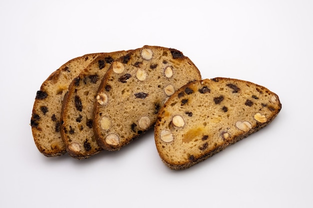 Ломтики сладкого десертного многозернового хлеба с орехами и изюмом. Здоровая диета. Изолированные на белом фоне.