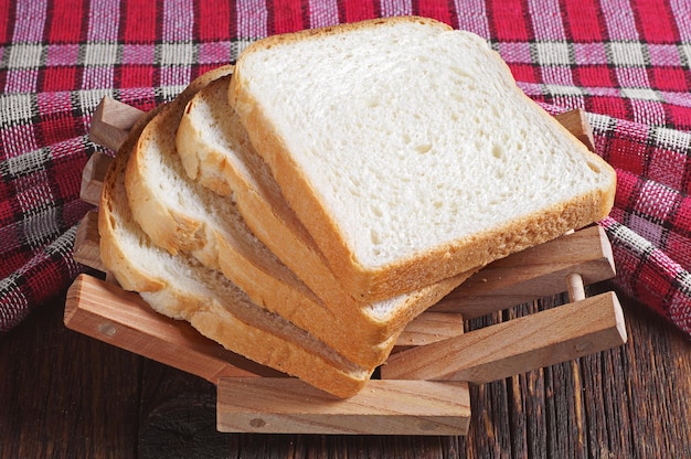 Ломтики тостового хлеба на деревянном столе со скатертью