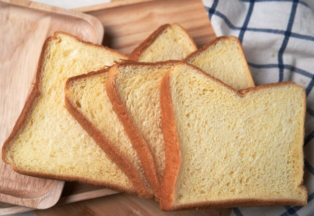 Slices of toasted bread on a wooden cutting board