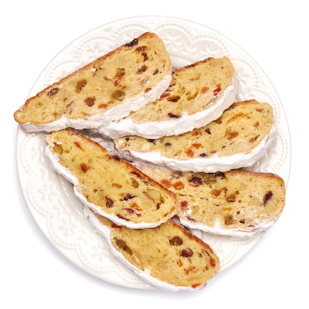 Photo slices of traditional christmas stollen cake with marzipan and dried fruit isolated on white ceramic...