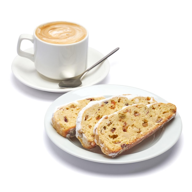 Slices of traditional christmas stollen cake with marzipan and dried fruit on white ceramic palte