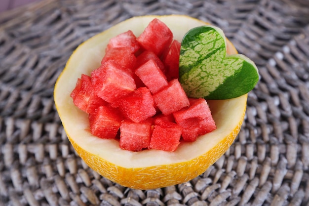 Slices of watermelon in melon bowl on wicker mat