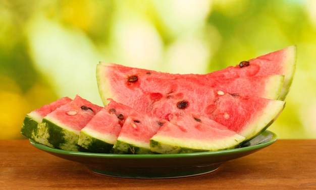 Slices of watermelon on the plate on green background closeup