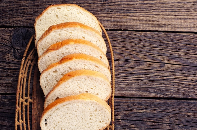 Photo slices white bread on vintage wooden table. top view