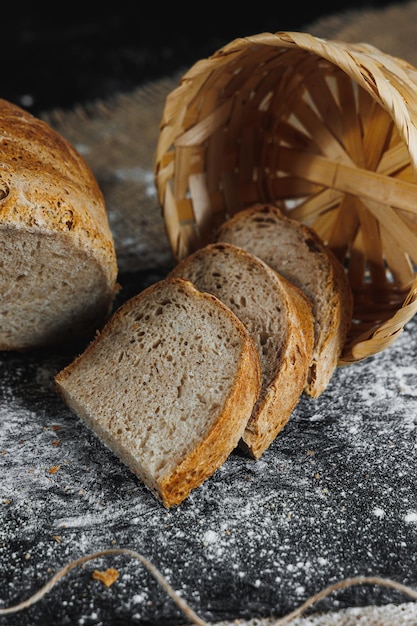 Slices of whole grain rye fresh bread on a dark background close up Fresh homebaked sourdough bread