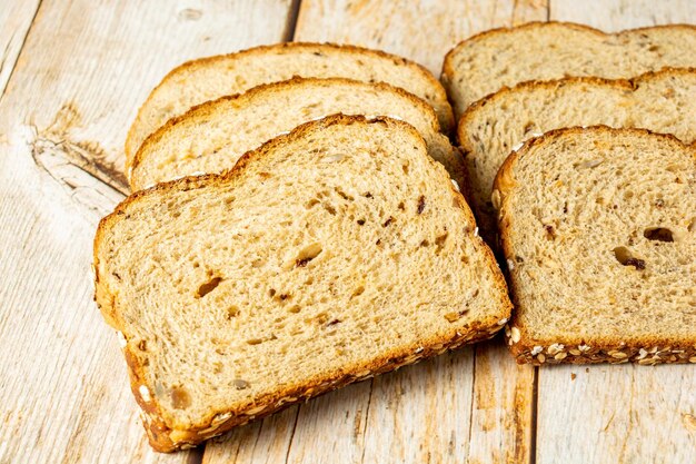 Slices of wholegrain bread with cereal on wooden table