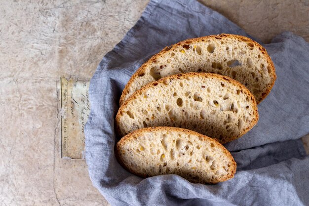 Slices of yeast-free bread with cereal lie on a blue napkin, space for text