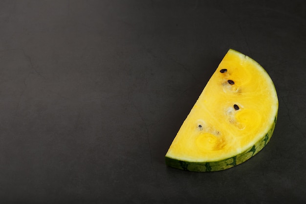 Slices of yellow watermelon on dark