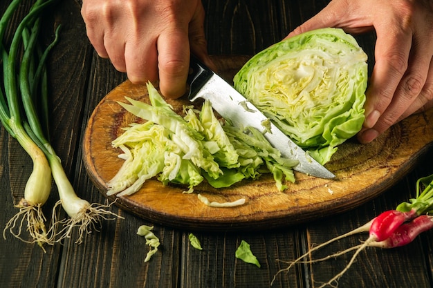 まな板でキャベツをスライス 新鮮な野菜を使った夕食のおいしいサラダ