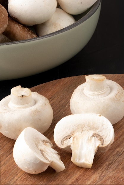 Slicing champignon on cutting board.