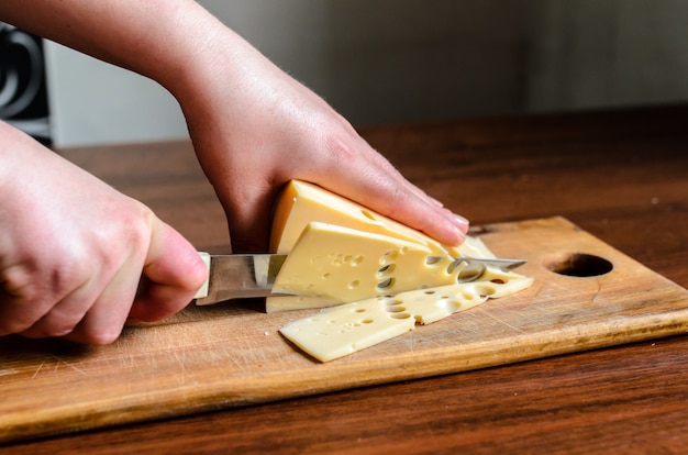 Slicing cheese on a wooden board.