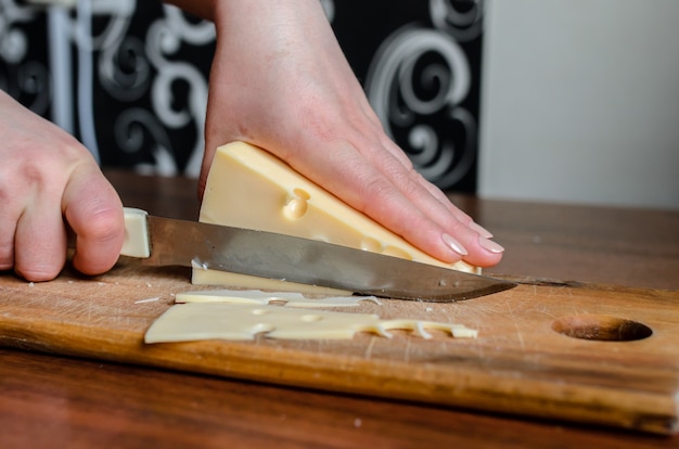 Slicing cheese on a wooden board