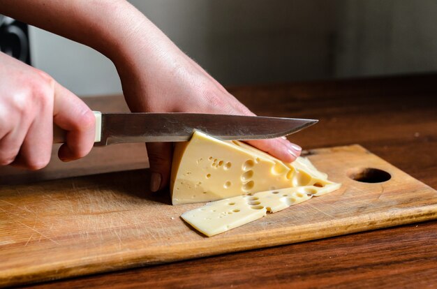 Slicing cheese on a wooden board.