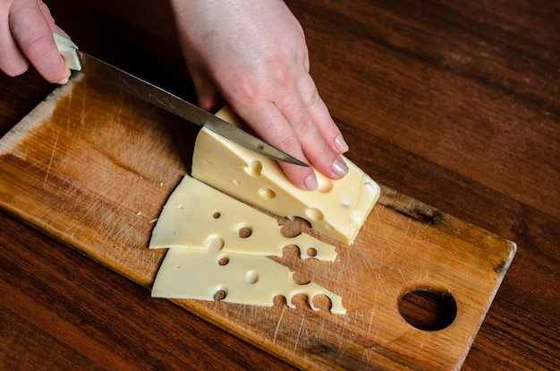 Slicing cheese on a wooden board.