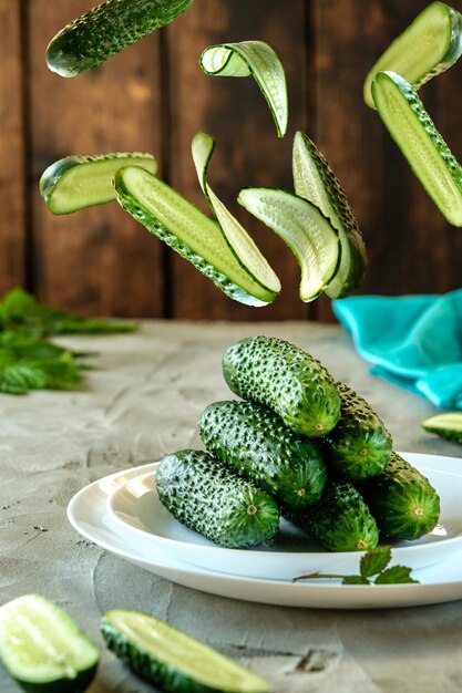 slicing cucumber on a fork creative photo of fresh cucumbers on a concrete background food levita